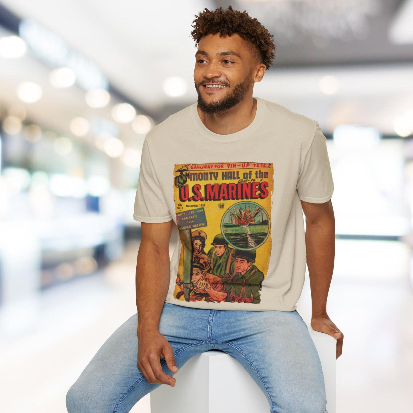 Man wearing a t-shirt with a graphic design of Monty Hall and U.S. Marines in a blurred indoor setting