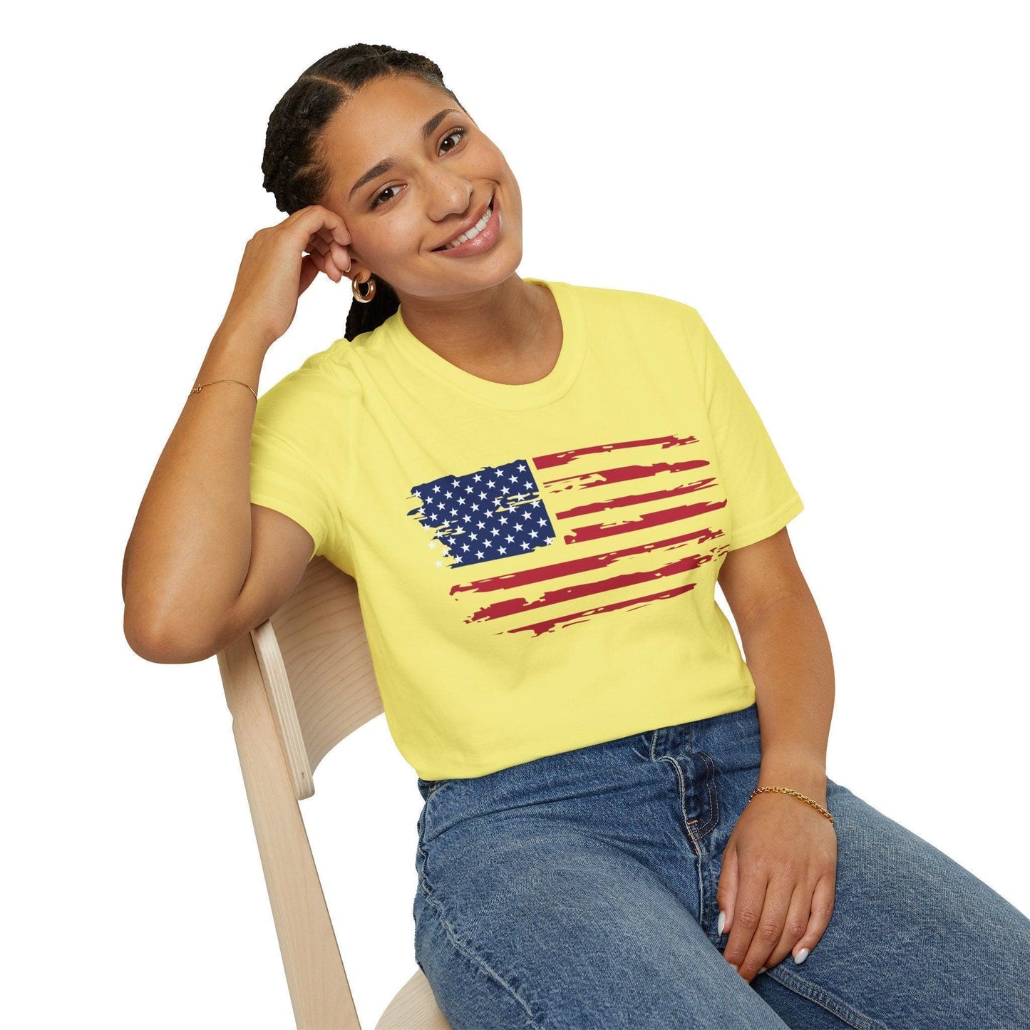 Close-up of distressed American flag printed on soft, relaxed fit T-shirt fabric showing frayed edges and vibrant colors