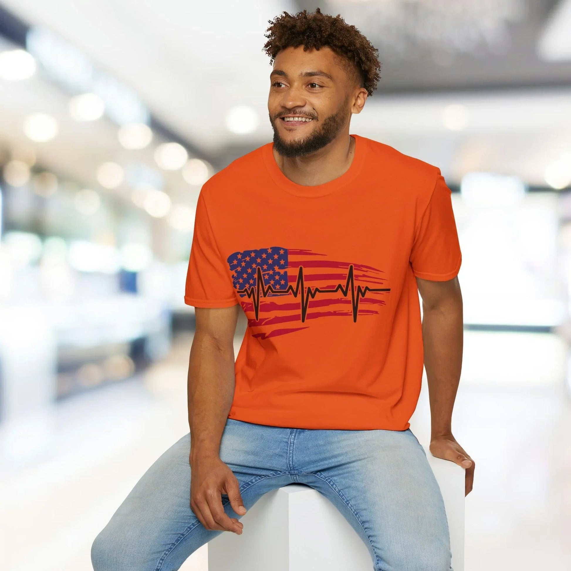 Close-up of the distressed flag heartbeat graphic on the chest of the unisex softstyle T-shirt, highlighting vibrant colors