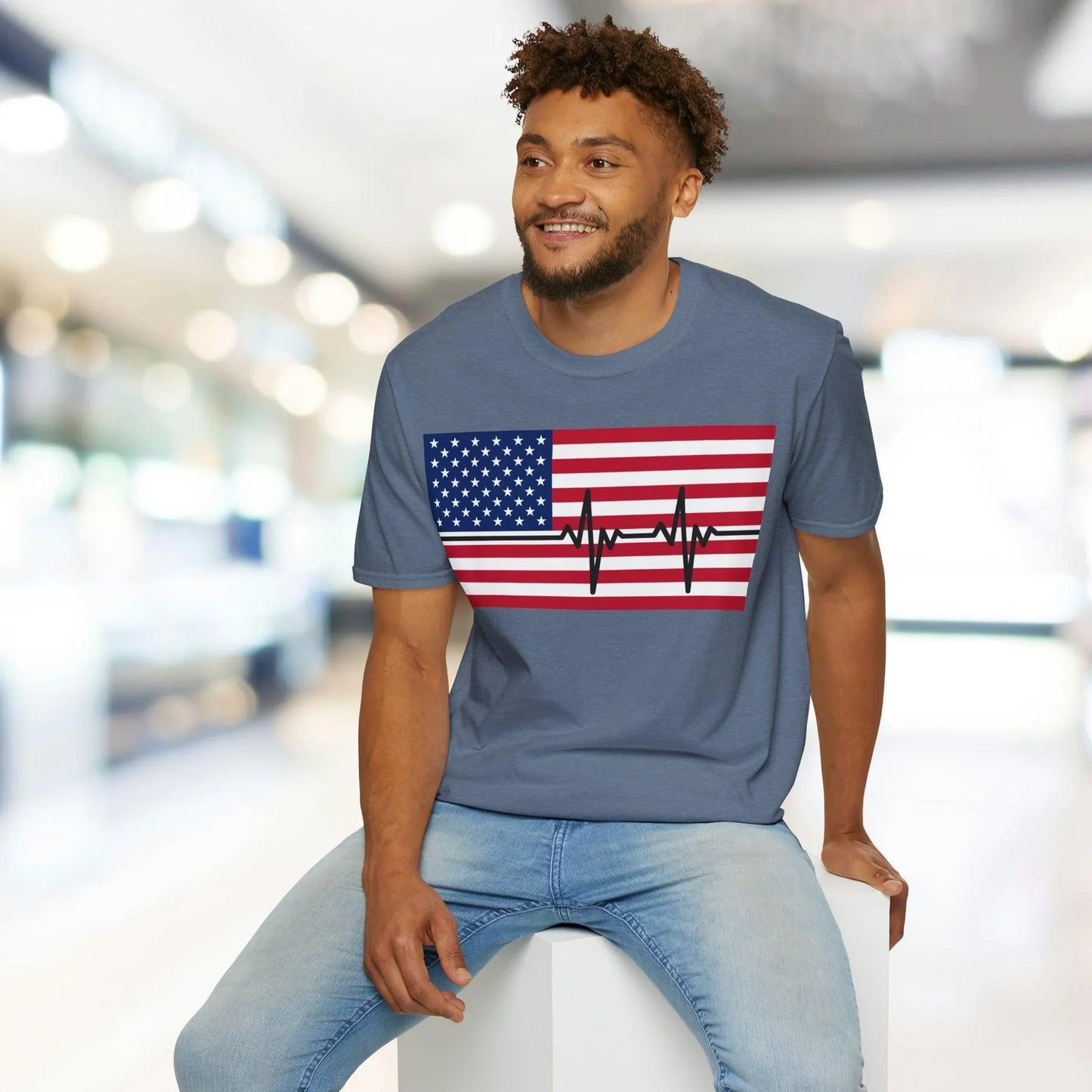 Close-up of the unisex T-shirt’s vibrant American flag heartbeat print on soft cotton fabric at a slight diagonal angle